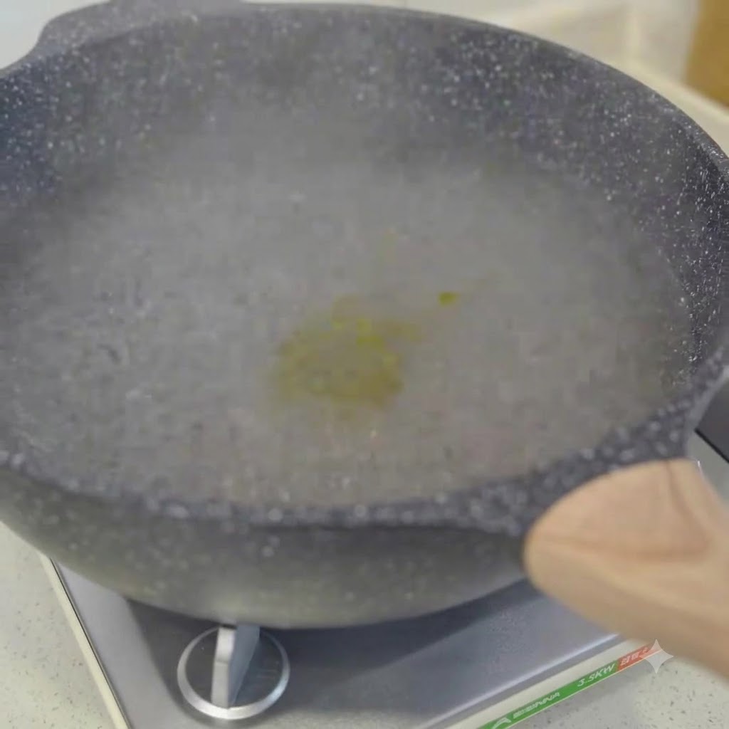 沸騰したお湯の中で箸で混ぜられているスパゲッティ。
