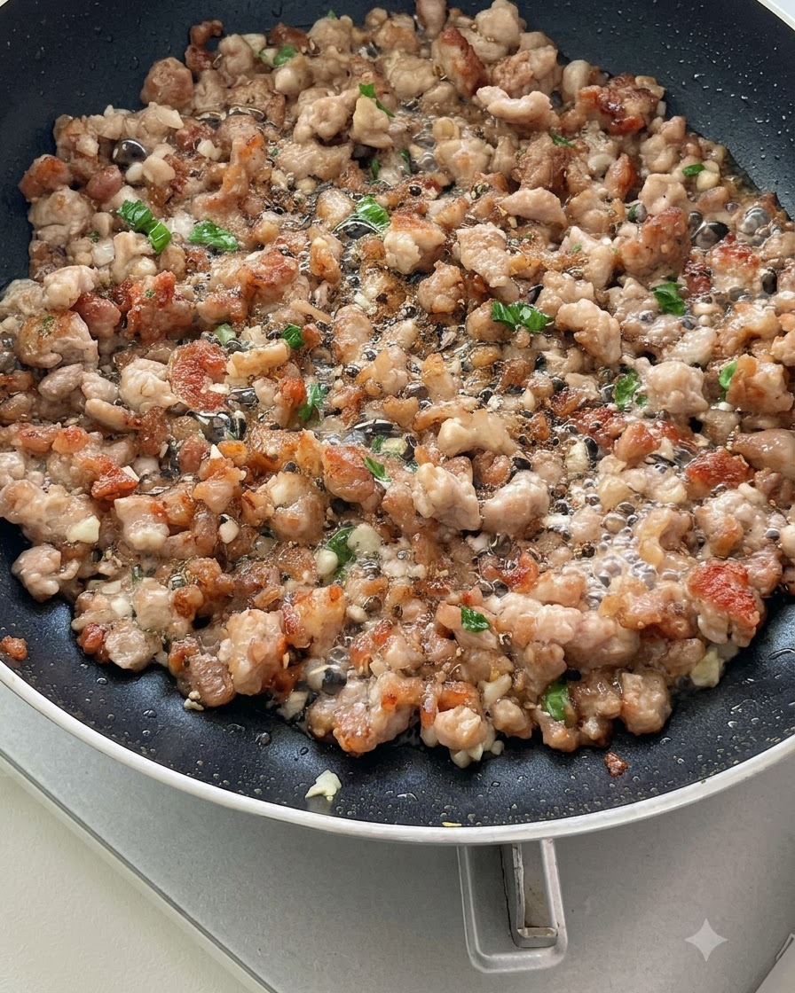 フライパンの中で、カットしたトマトがひき肉や香味野菜と一緒に炒められ、果汁が出始めているところ。