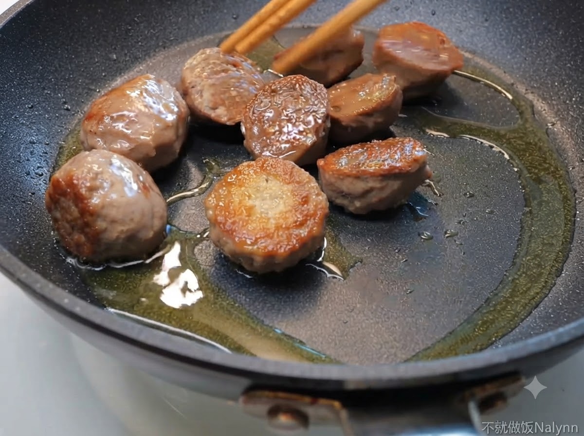 油をひいたフライパンでミートボールを炒め、菜箸で動かしている様子。
