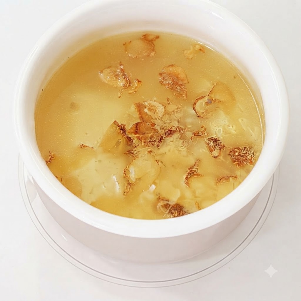 スープを作るために水の中で煮られているニンニクの皮とクローブ。