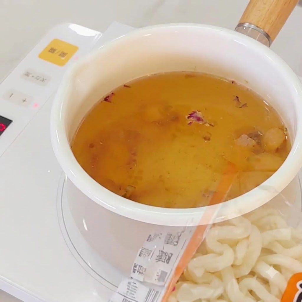 沸騰したガーリックだしに加えられているラーメンの麺。