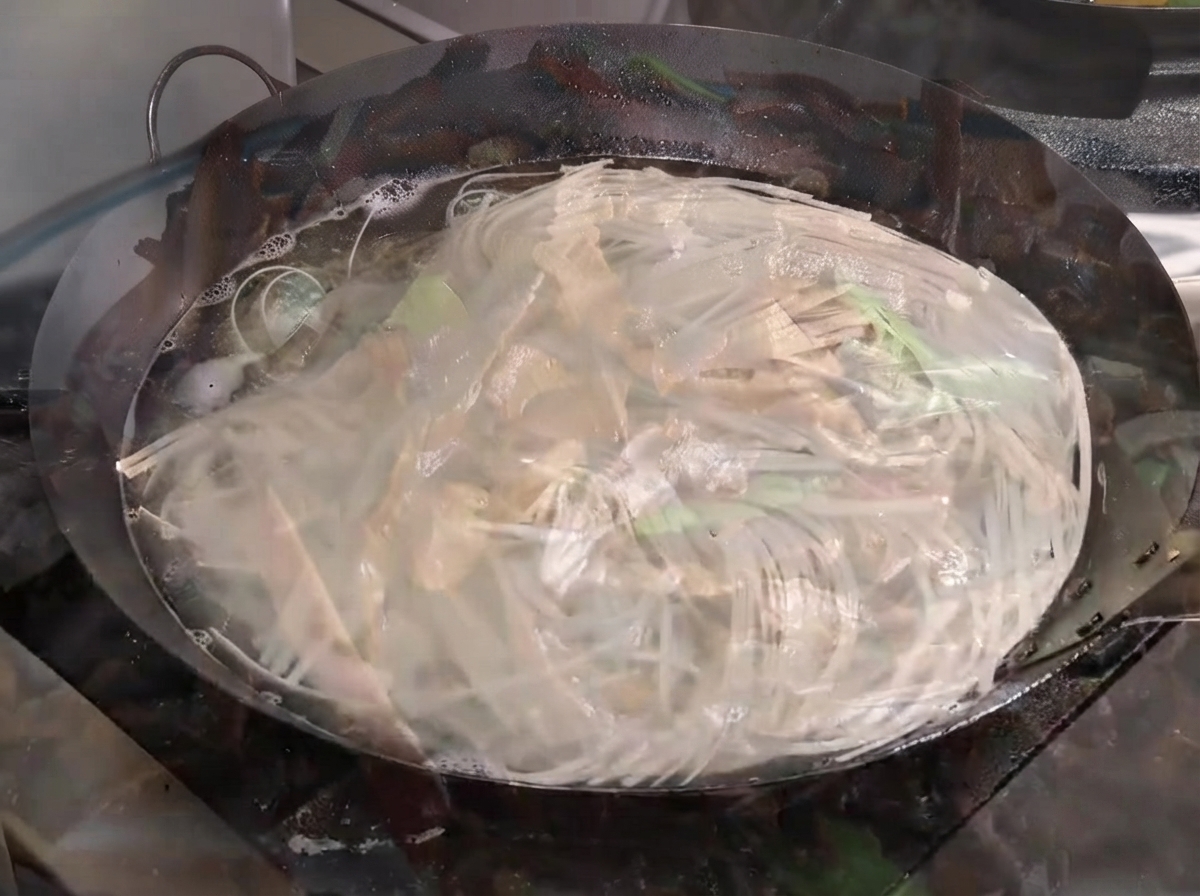 一大锅水中面条正在剧烈沸腾翻滚。
