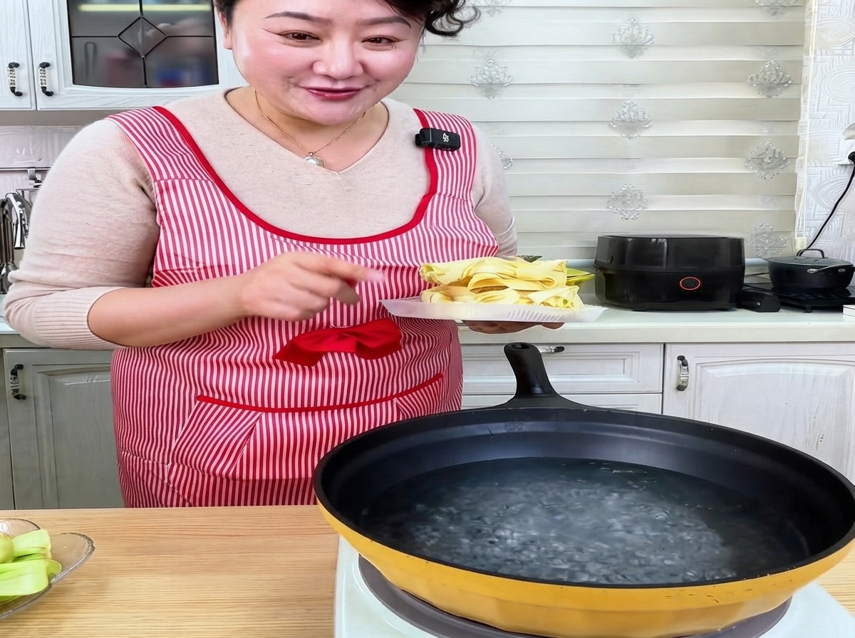 沸騰した鍋に乾燥平打ち麺を入れている様子。