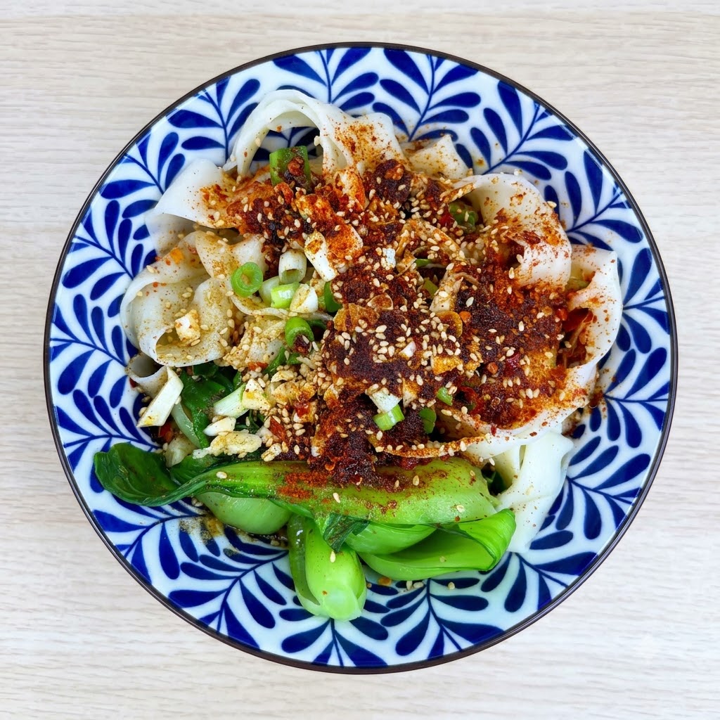 麺とトッピングが入ったボウルに、薄口醤油、酢、オイスターソース、砂糖を加えている様子。