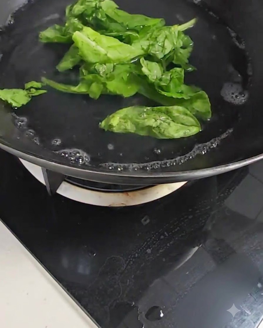 コンロで沸騰している鍋の中で、新鮮なチンゲン菜の葉を茹でている様子