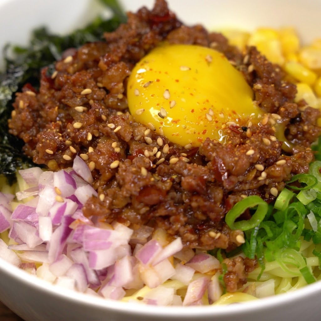 鍋の熱湯の中で黄色い中華麺を茹でている様子