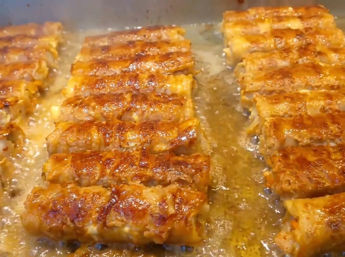 具材をのせた豚バラ肉を手でしっかりと巻き込んでいる様子。