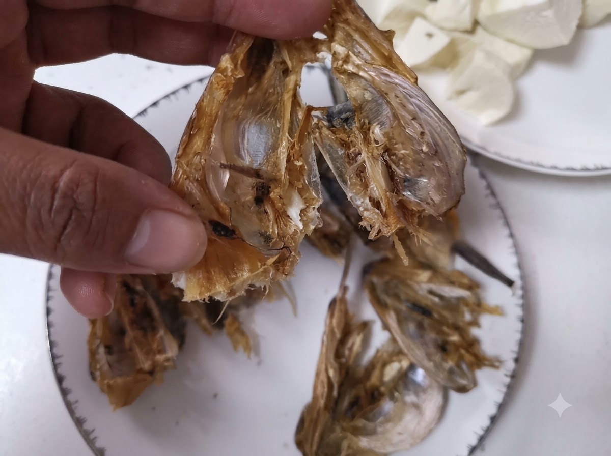 ナイフを使って干し魚の頭を開き、掃除しているクローズアップ画像。