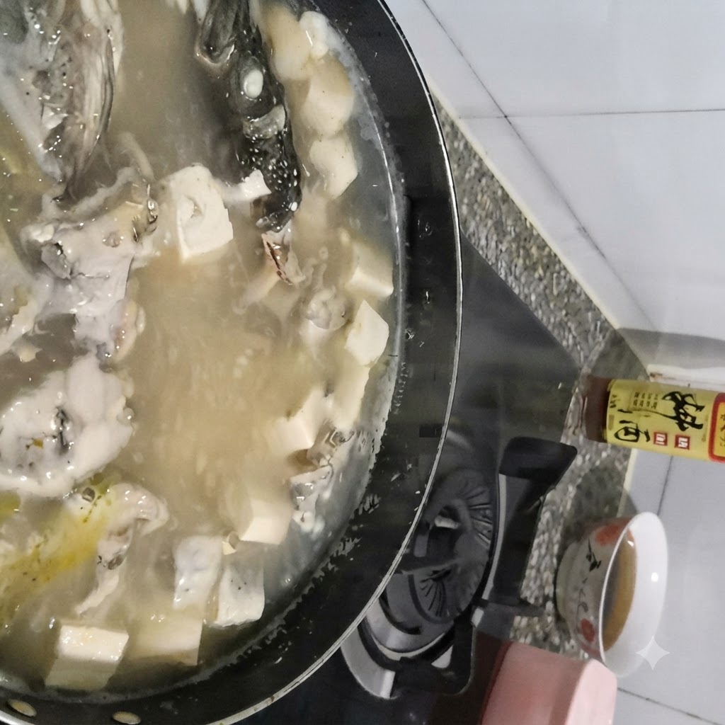煮立ったスケソウダラと豆腐のスープの表面から、スプーンですくい取るようにアクを除去している様子。