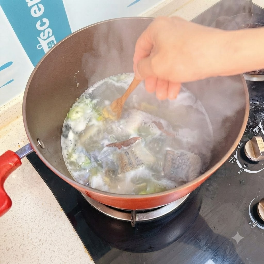 木製のスプーンを使って、グツグツと煮えるスープの中に豆腐のキューブを入れているところ。