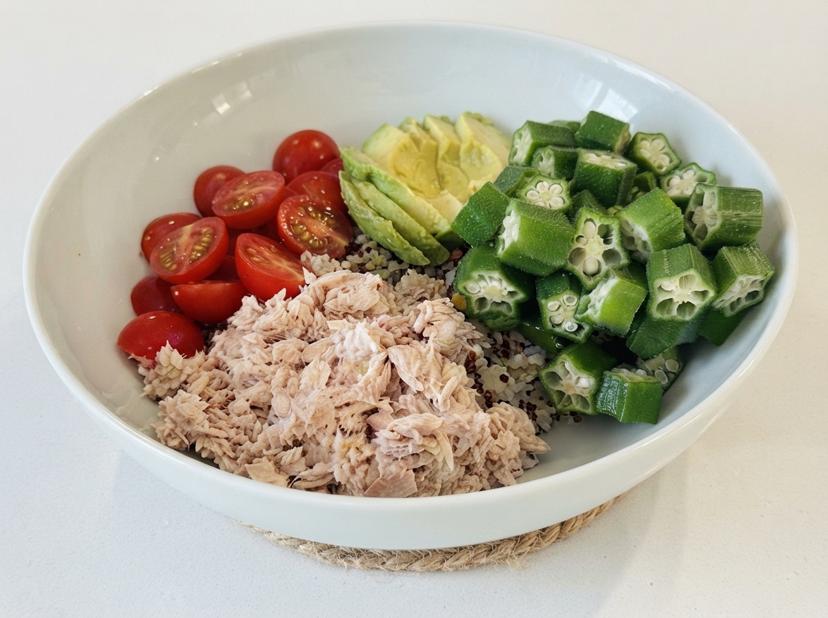 ご飯を敷いたベースの上に、味付けしたツナ、ミニトマト、スライスアボカド、オクラをエリアごとに盛り付けた白いボウル。
