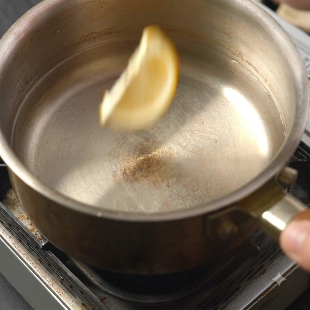 液体が入った鍋に1枚のレモンスライスが落ちていく瞬間。