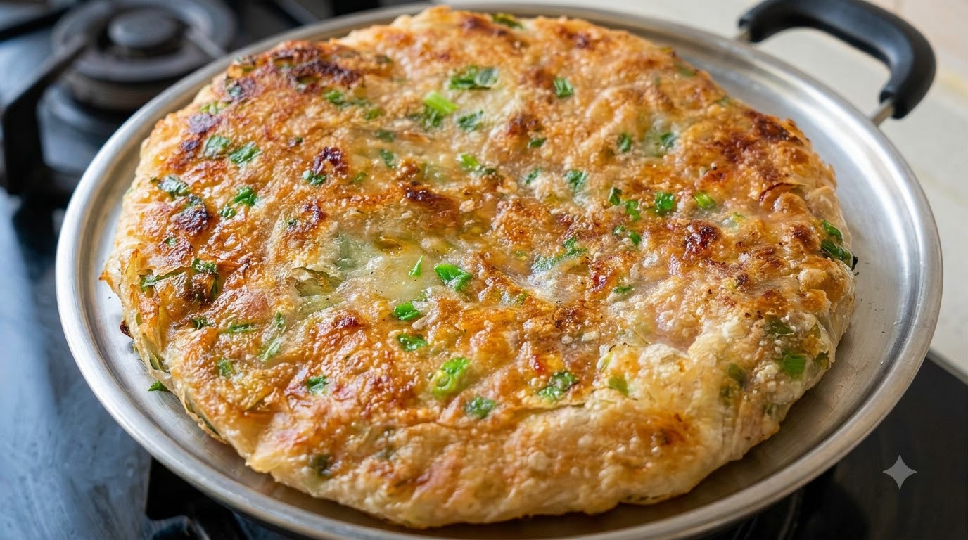 フライパンで黄金色にこんがり焼き上げられたネギ肉餅。刻んだ青ネギが散りばめられたサクサクの生地が食欲をそそります。
