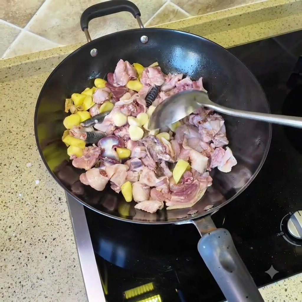 皮をむいたにんにくと乾燥唐辛子を鶏肉と生姜が入った中華鍋に加える様子