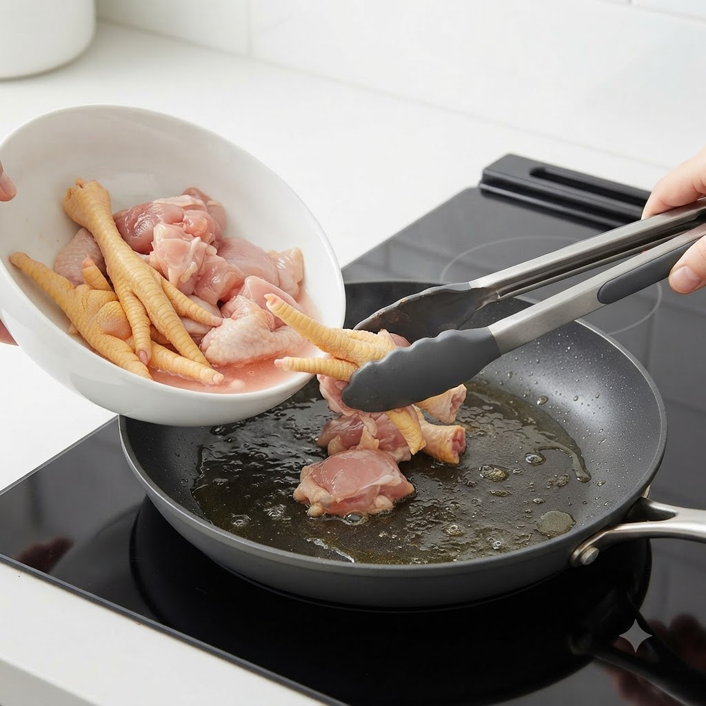 トングを使って、生の鶏肉を沸騰したお湯の入った鍋に入れている様子。