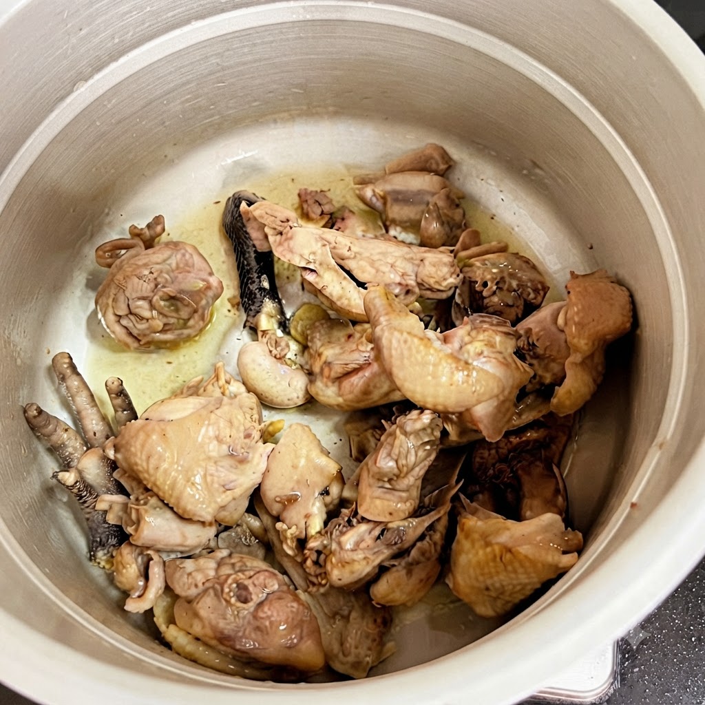 圧力鍋の中に入った炒めた鶏肉