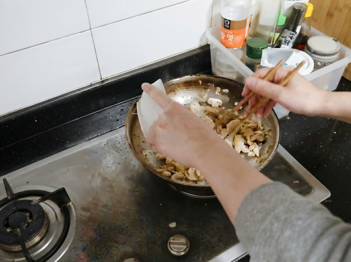 炒めたマッシュルームと玉ねぎの入ったフライパンに戻し入れられる調理済みの鶏肉のスライス。