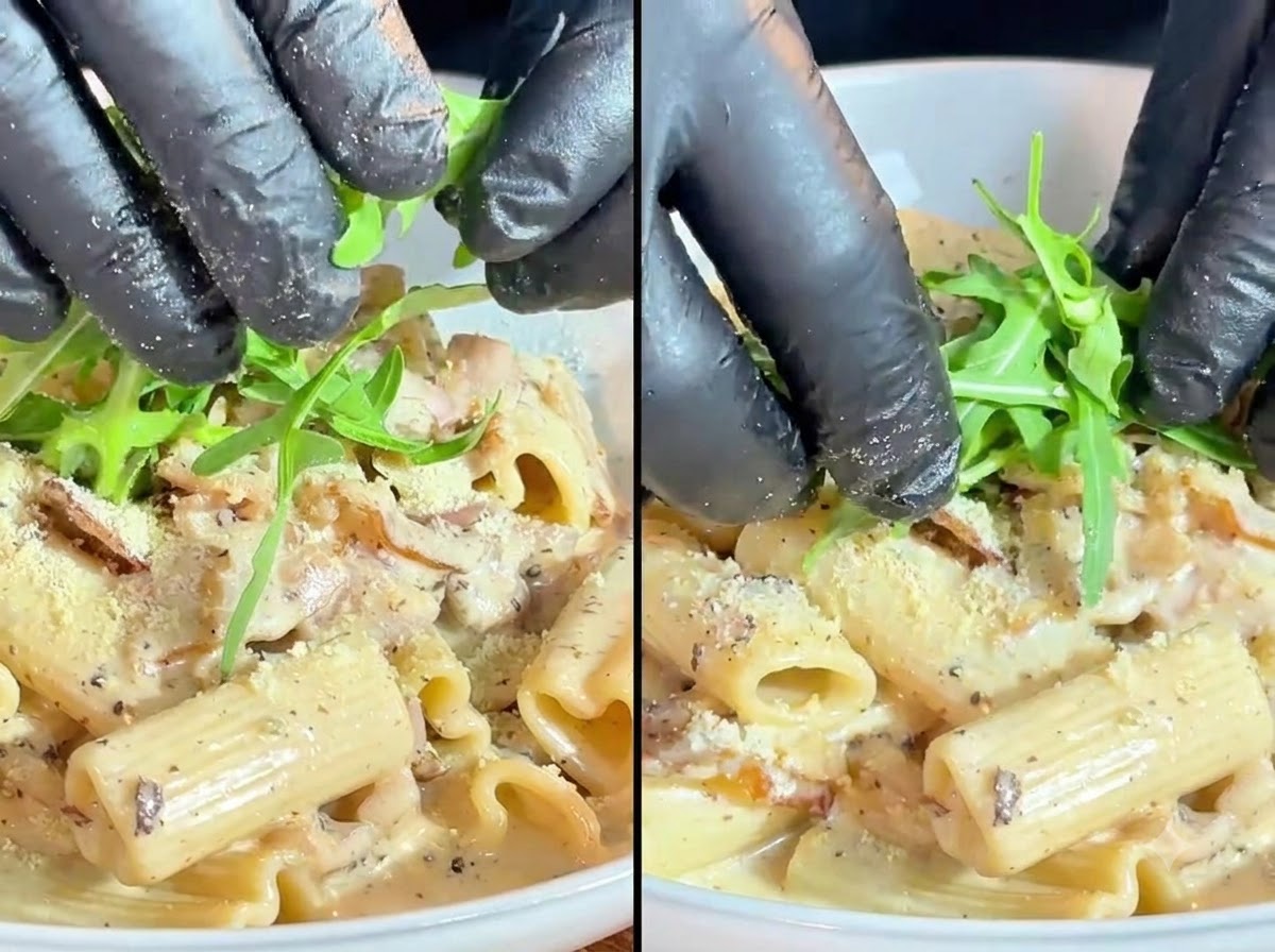 クリーミーなパスタの上に、鮮やかな緑色のルッコラの葉とミニトマトをトッピングとして丁寧に添えている様子。