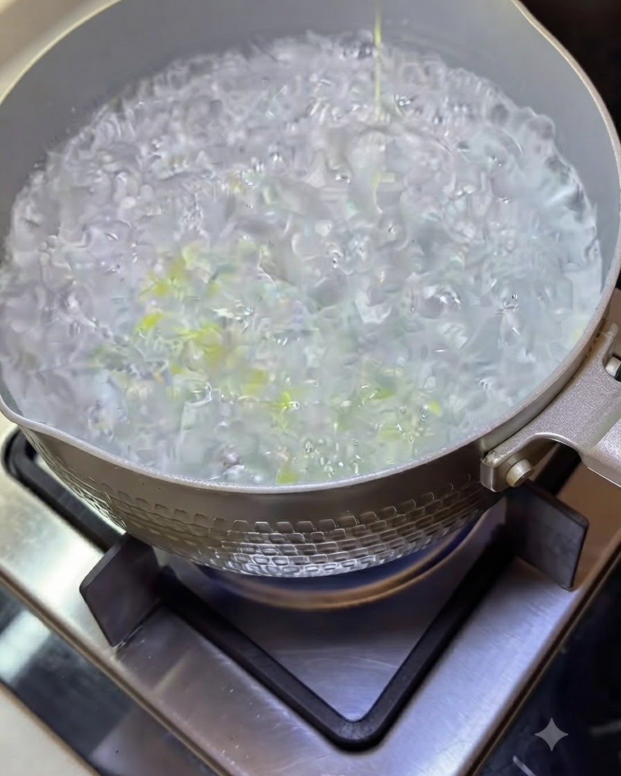 沸騰したお湯の中で泡立ちながら茹でられているスパゲティの麺。