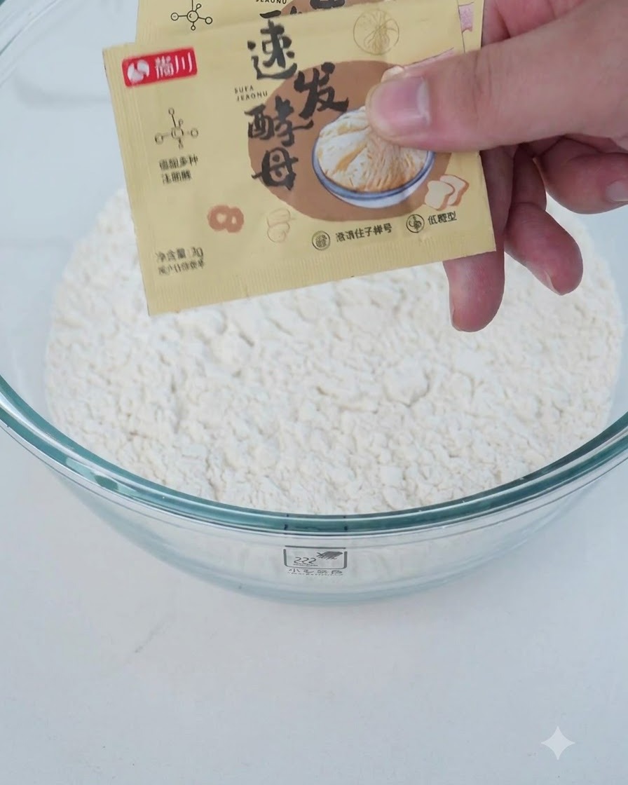 ボウルに小麦粉やイーストなどの粉類と水分を加えている様子。