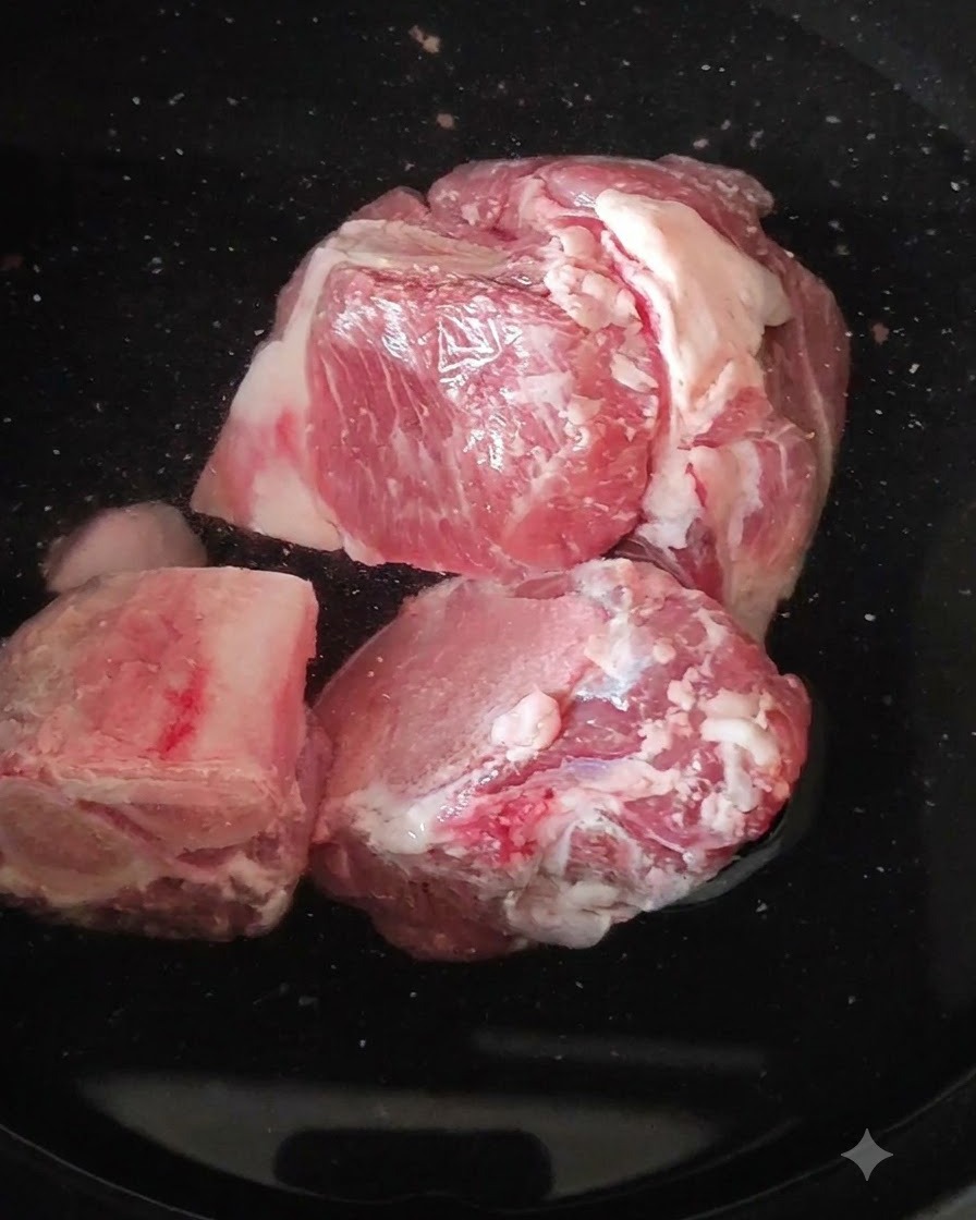 鍋で沸騰したお湯に入れられた生の豚骨。