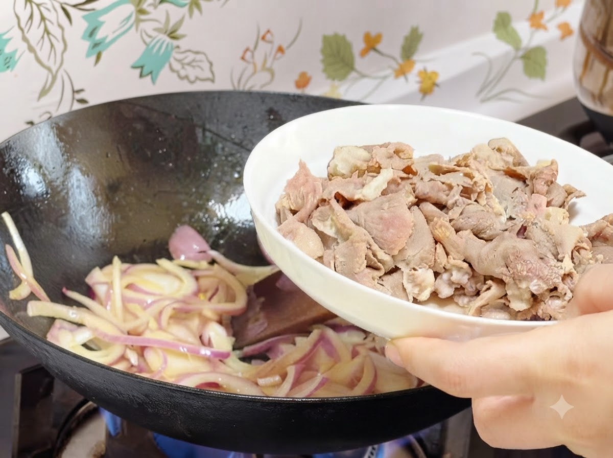 白い皿に盛られた湯通し済みの牛肉ロールを、玉ねぎの入った中華鍋に投入しているところ