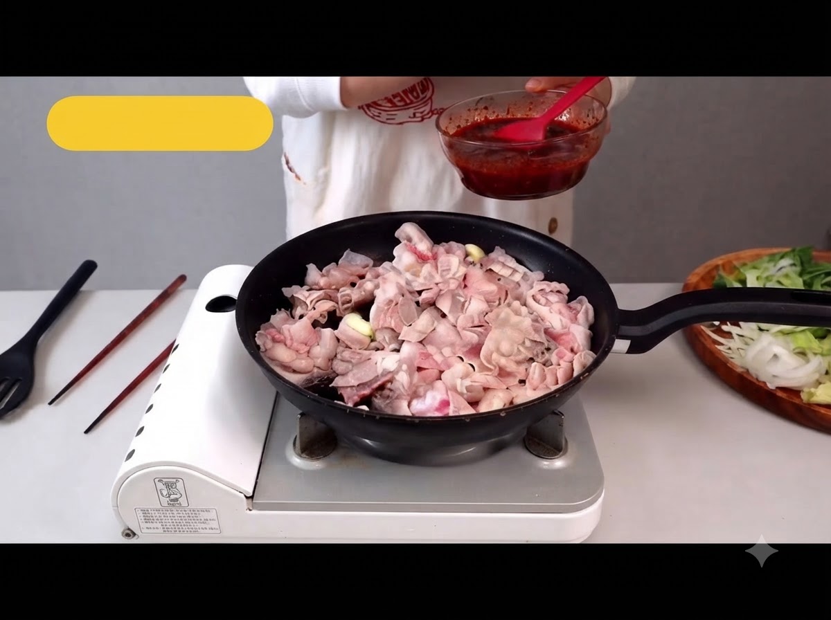 フライパンで薄切りの豚バラ肉を炒め、脂が出ている様子。