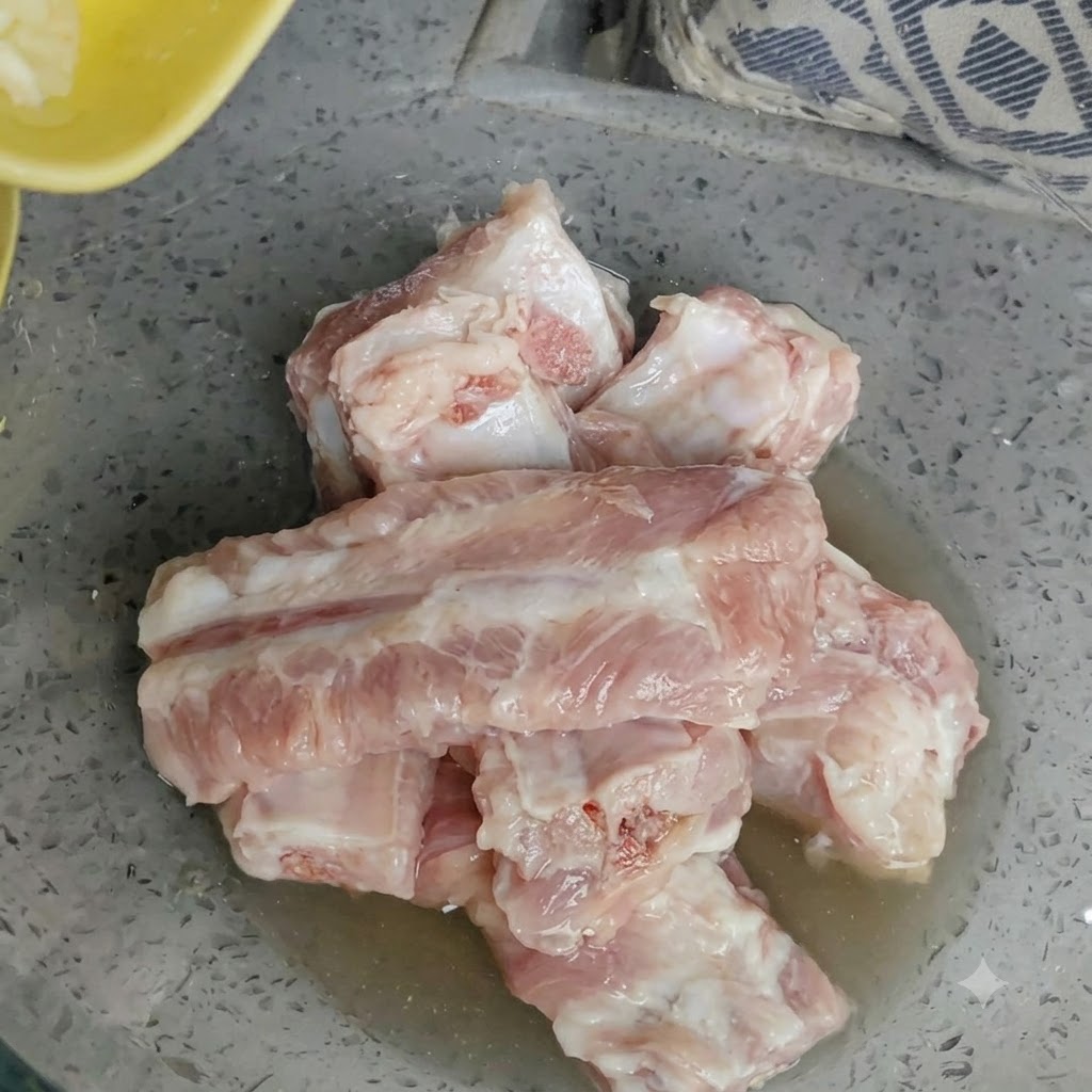 みじん切りにした新鮮なにんにくを豚スペアリブに加えている様子。
