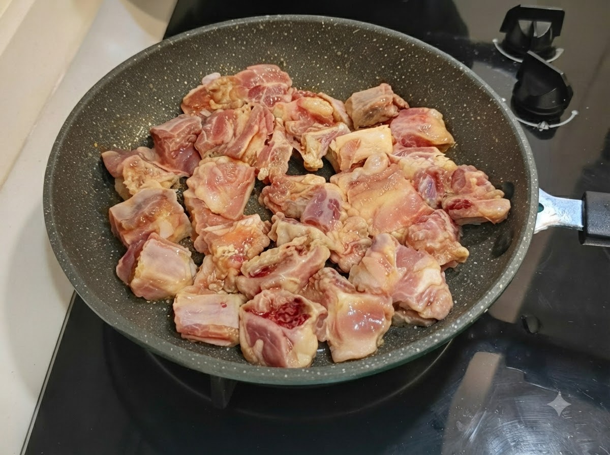 コンロ上のフライパンに、下味をつけた豚スペアリブがきれいに並べられている様子。