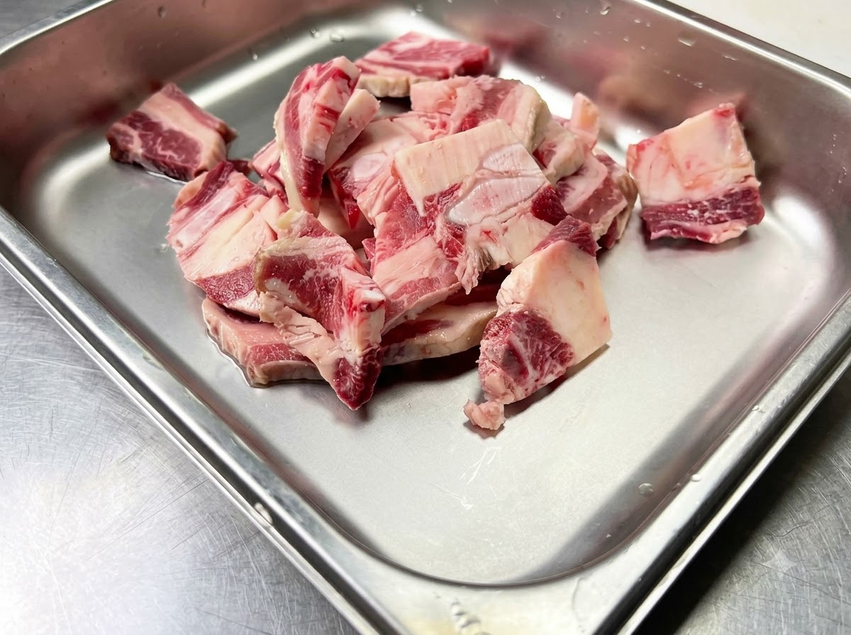 調味料を加えるために清潔な金属製容器に入れられた生の牛カルビ。