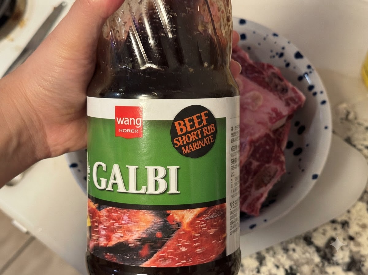 生肉が入ったボウルに韓国風BBQカルビソースのボトルからソースを注いでいる様子。