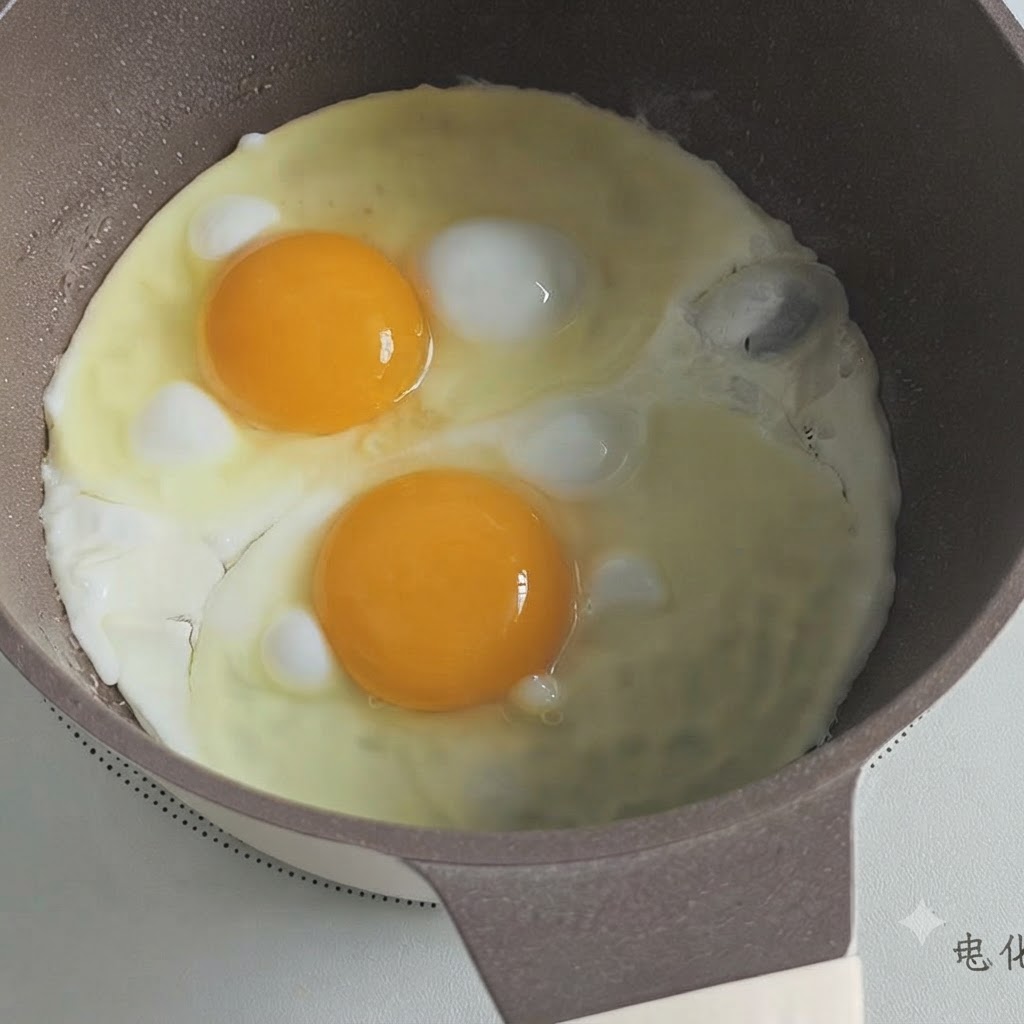 鍋で目玉焼きを2つ焼き、縁が固まり始めている様子