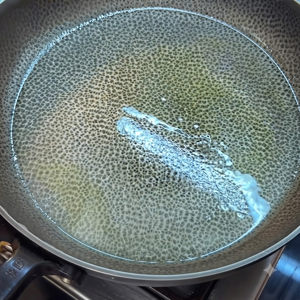 油を引いたフライパンで、溶き卵に火が通り、木べらで炒り卵状にほぐされている様子。