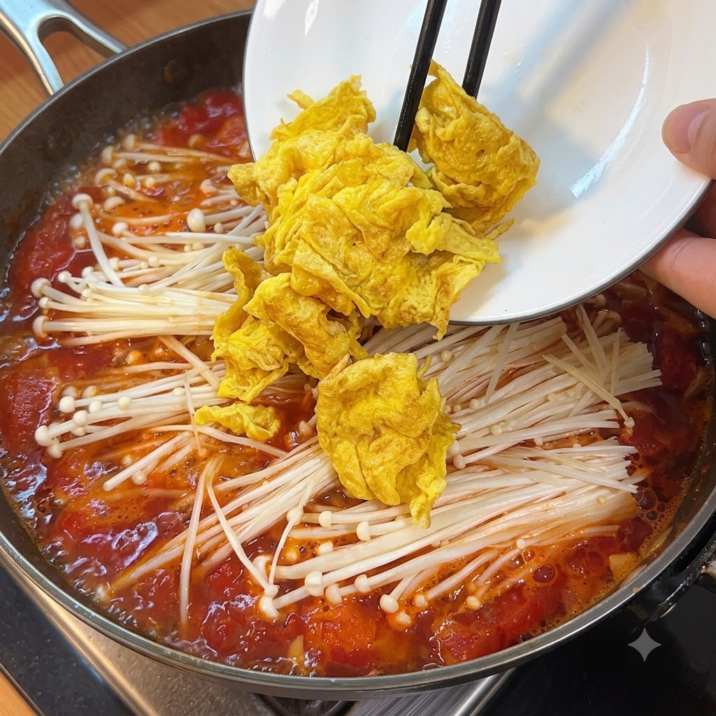 キノコやトマトが入った沸騰したスープの鍋に、サイコロ状の絹ごし豆腐が加えられている様子。