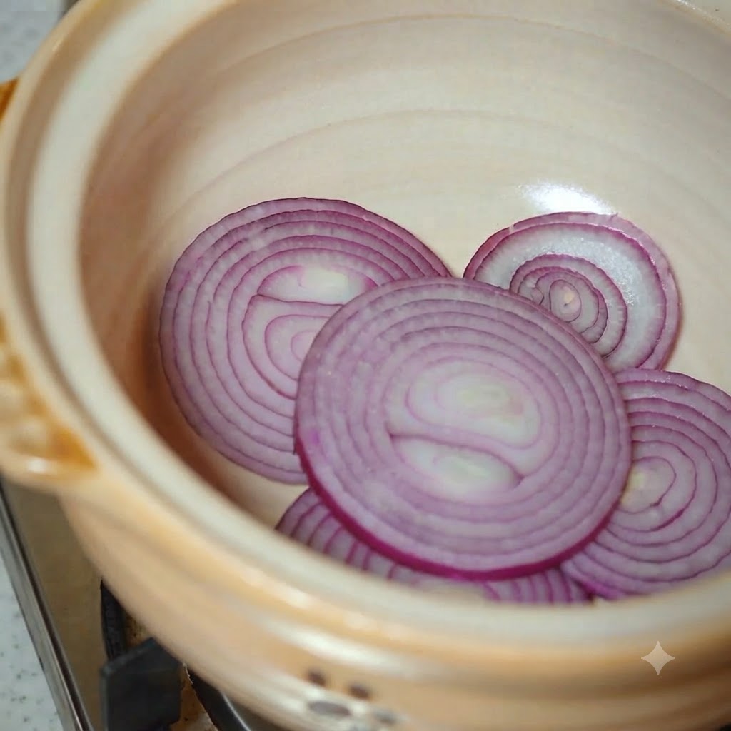 白菜とスライスしたズッキーニを土鍋に入れている様子。
