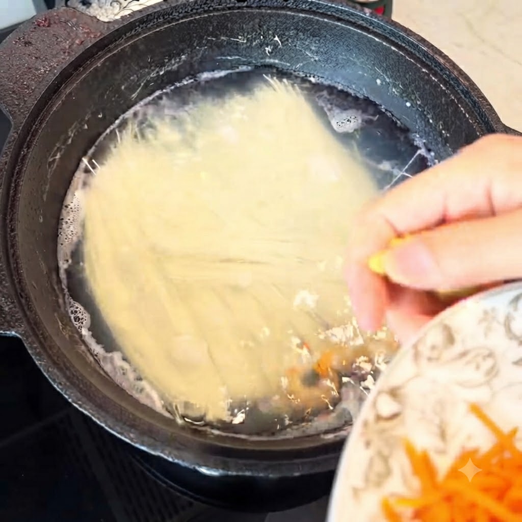 沸騰した鍋に千切り生姜を加えている様子。