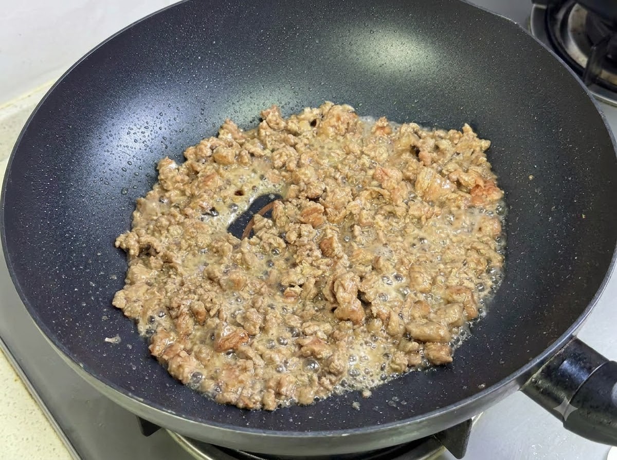 黒い中華鍋の中で調理されている牛ひき肉。