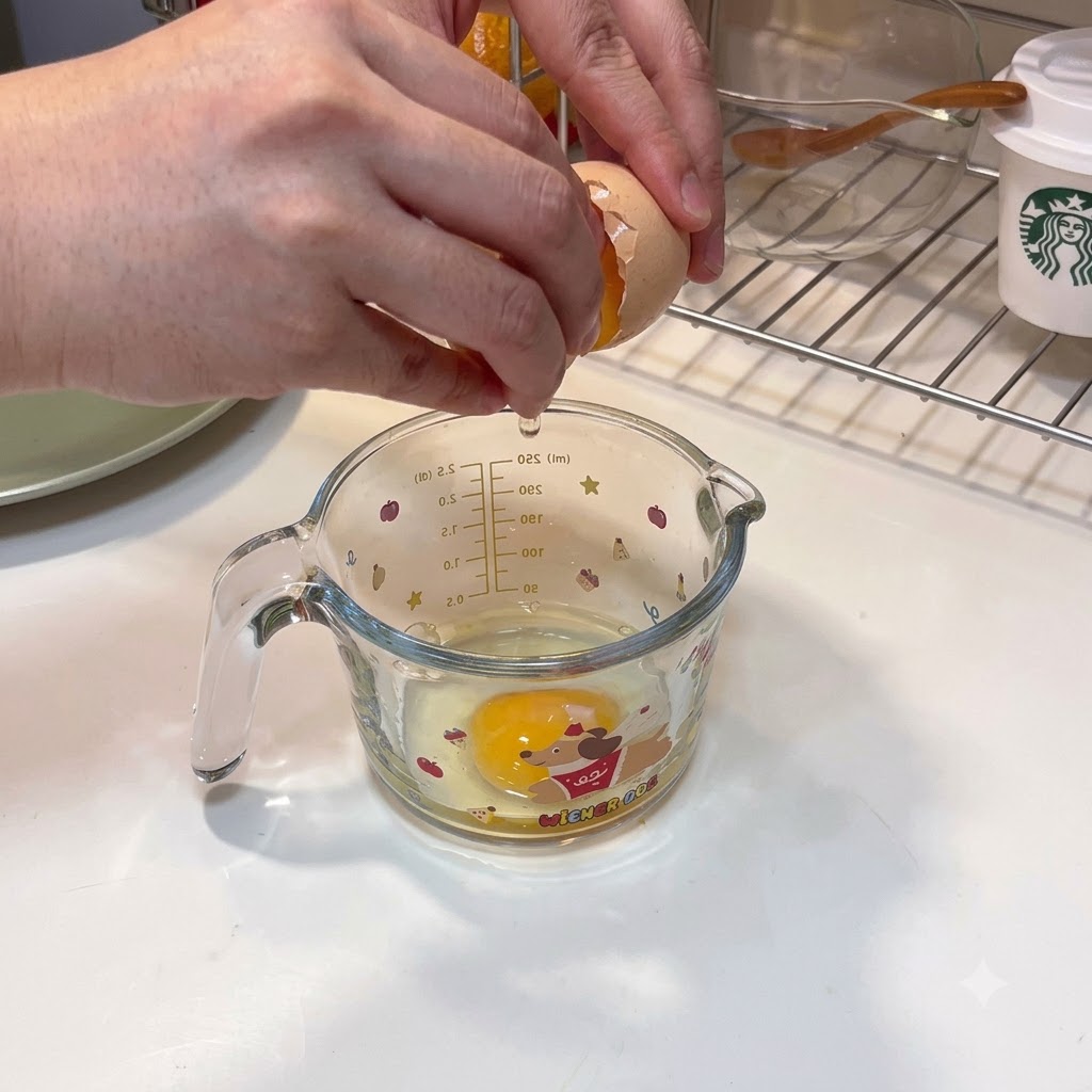 計量カップに割った2個の卵と水溶き片栗粉を注ぎ入れている様子。