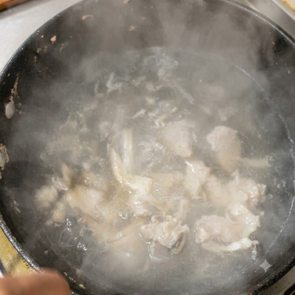 沸騰している豚肉のスープに、刻んだ熟成キムチを投入している様子。