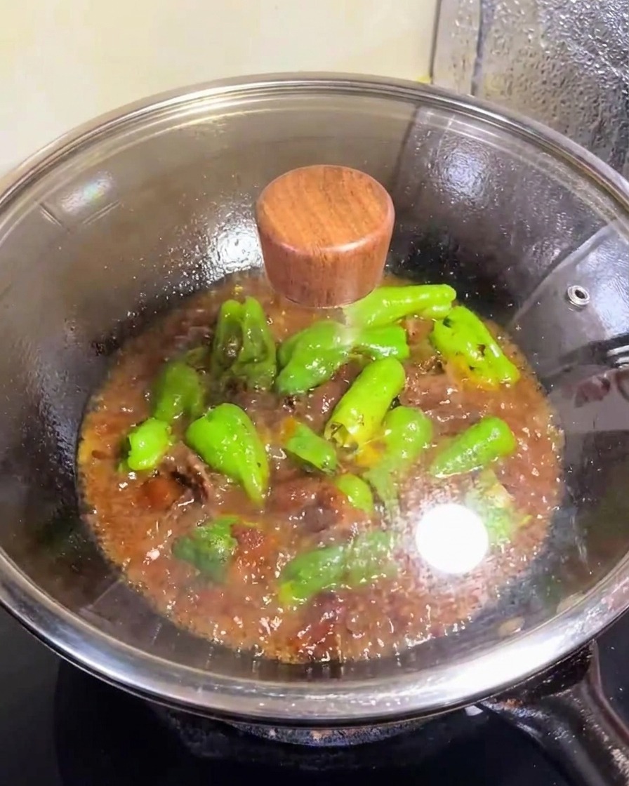 ガラスの蓋をして火にかけているピーマンの肉詰め